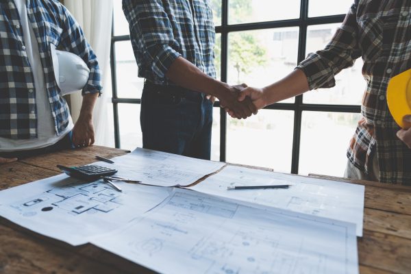 Businessman and engineer handshake business investment in village construction project together, teamwork concept.